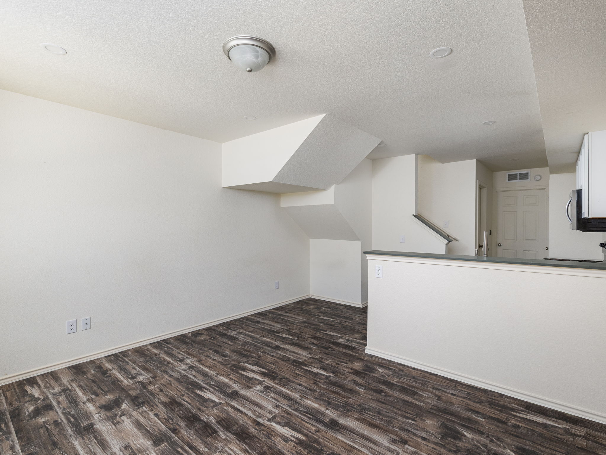 230 Debus Drive, Unit 108B Taylor, TX 76574 - Photo 10 of 16 Unfurnished living room featuring dark wood-type flooring and a textured ceiling