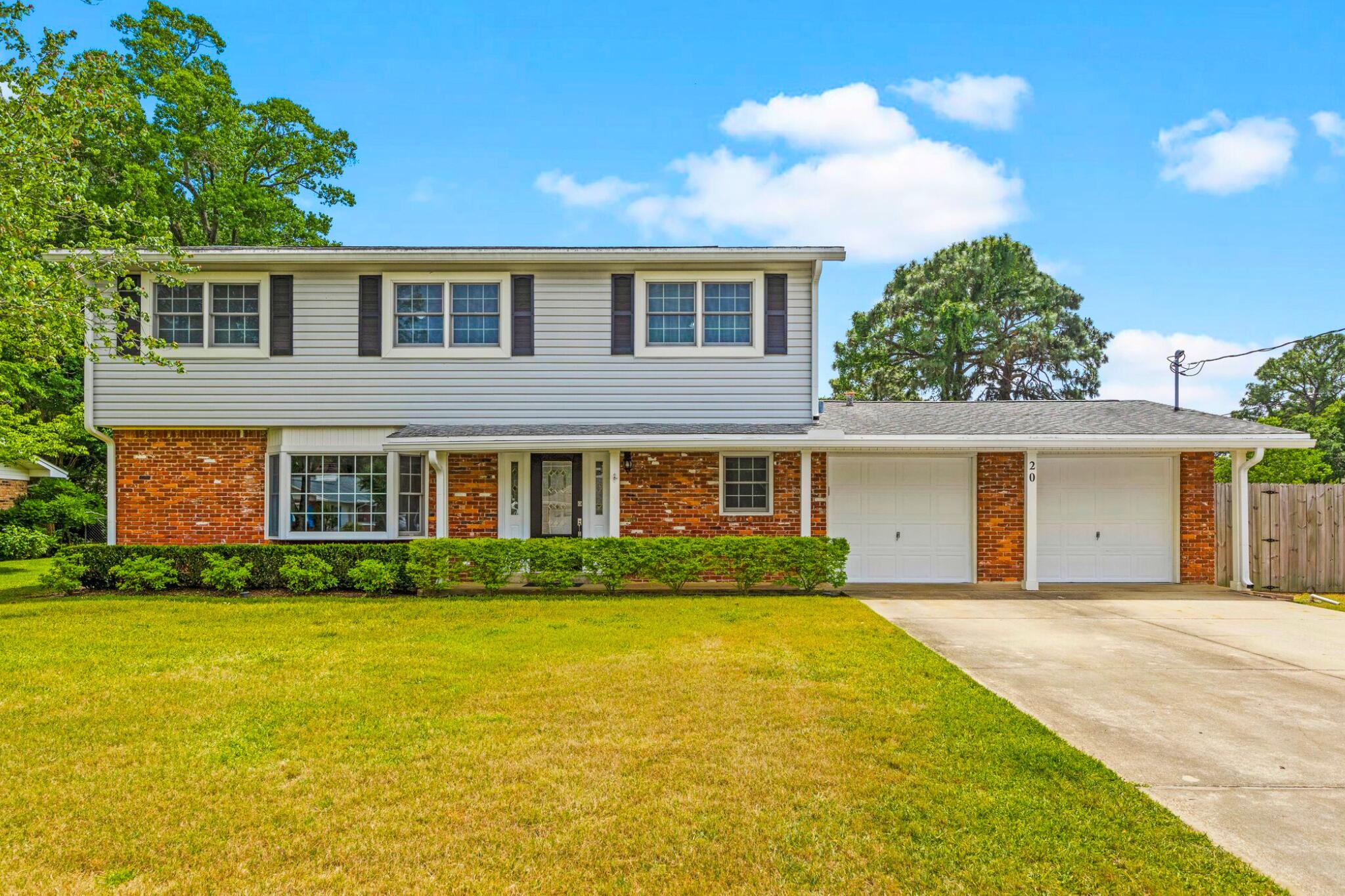 a front view of house with yard and trees around