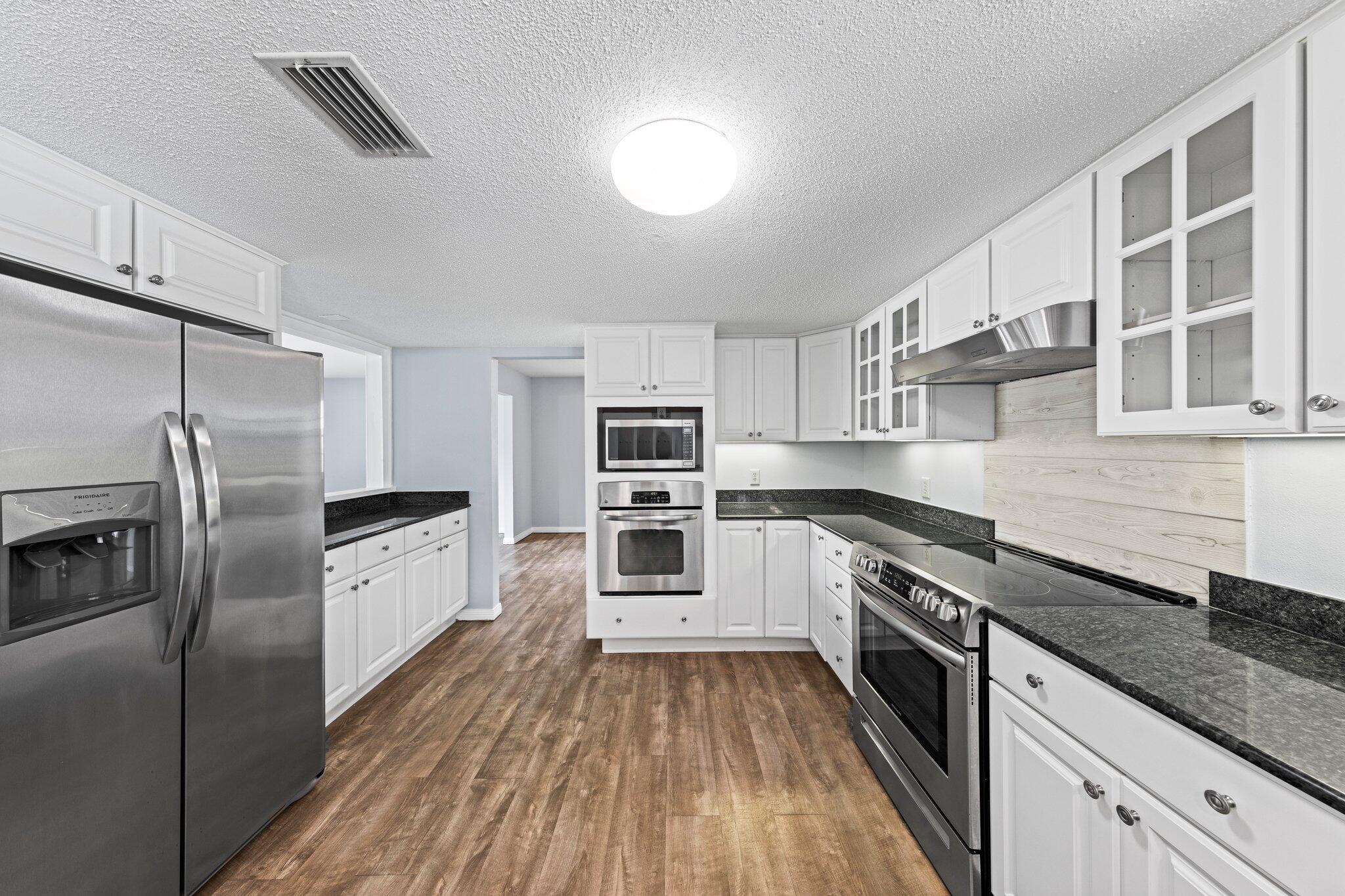 20 Maple Avenue Shalimar, FL 32579 - Photo 6 of 55 a kitchen with stainless steel appliances granite countertop a stove and a refrigerator