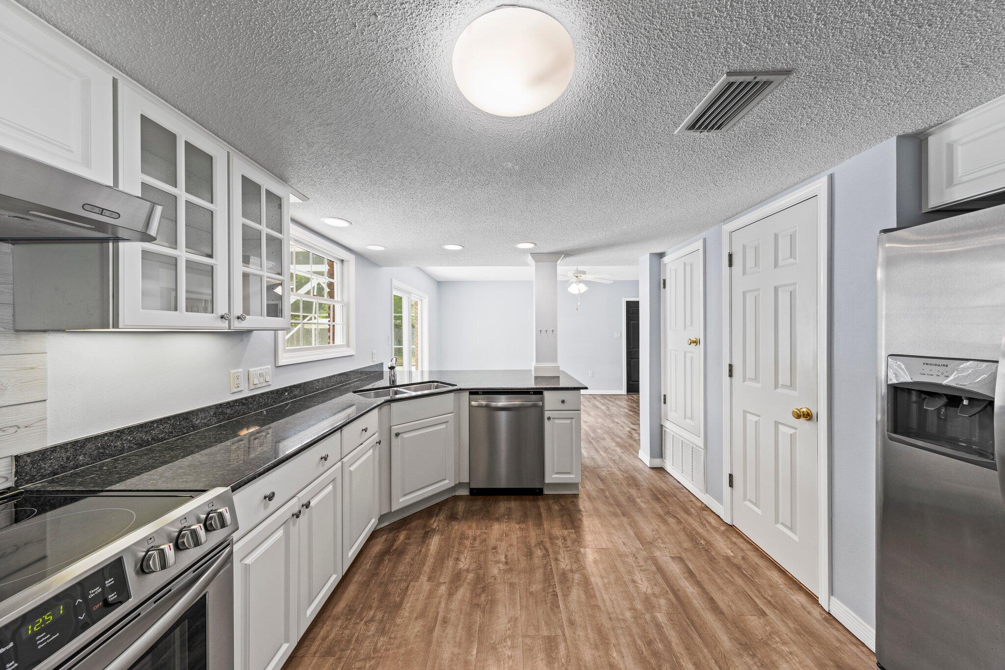 20 Maple Avenue Shalimar, FL 32579 - Photo 7 of 55 a large kitchen with a stove top oven a refrigerator a sink and dishwasher with wooden floor