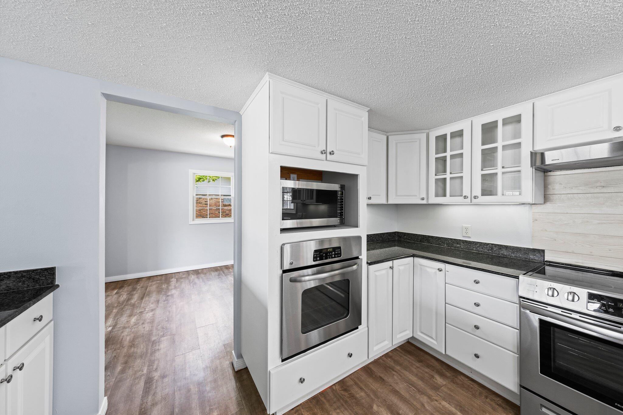 20 Maple Avenue Shalimar, FL 32579 - Photo 8 of 55 a kitchen with cabinets stainless steel appliances and wooden floor