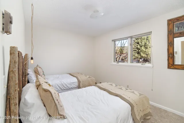 a bedroom with two bed and a window