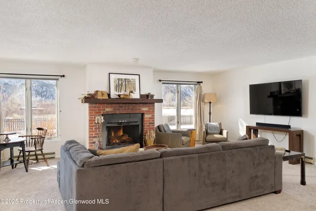 a living room with furniture a flat screen tv and a fireplace