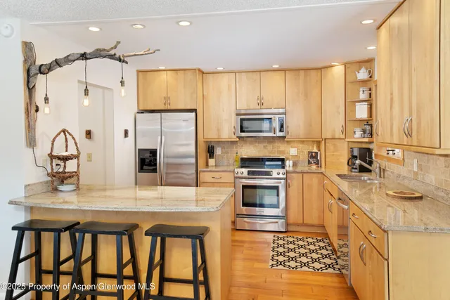 a kitchen with stainless steel appliances a sink stove and refrigerator