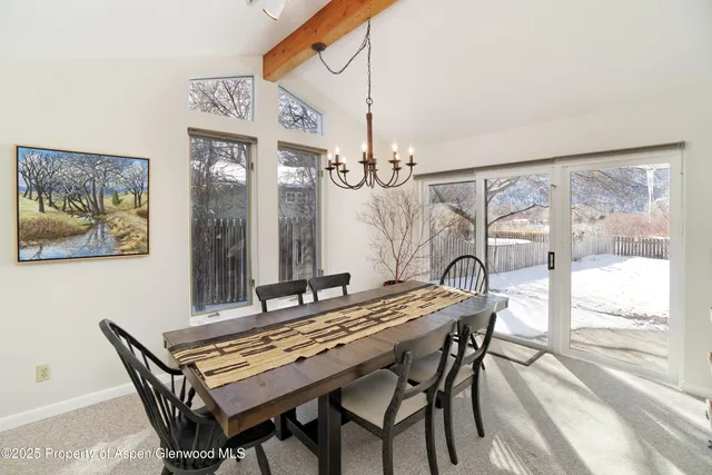 a dining room with a wooden table and chairs