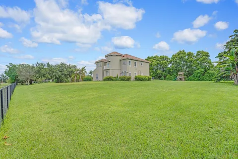 a large house with a big yard and large trees
