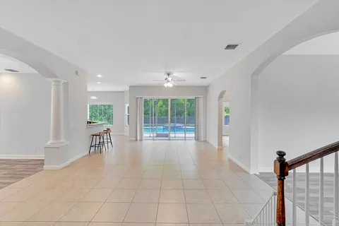 an empty room with a window and ceiling fan