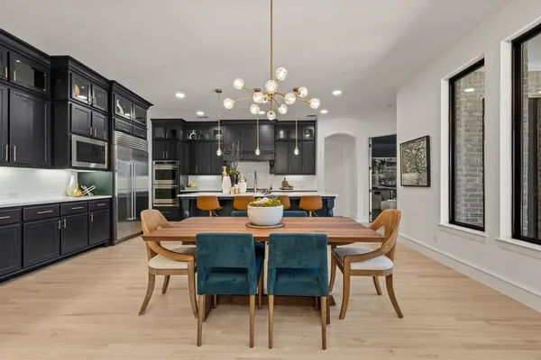 a kitchen with stainless steel appliances kitchen island granite countertop a dining table chairs and granite counter tops