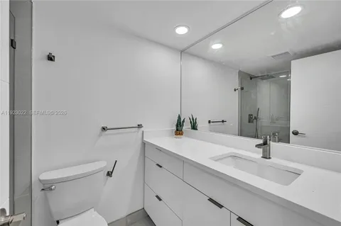a bathroom with a sink toilet and a mirror