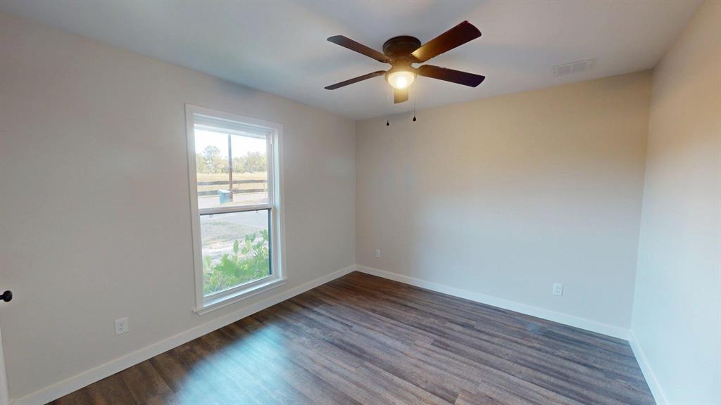1110 Mill Run Road Athens, TX 75751 - Photo 15 of 32 an empty room with wooden floor and windows