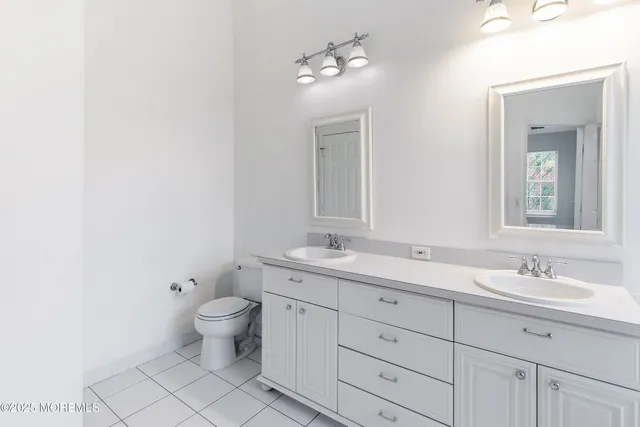 a bathroom with a granite countertop toilet a sink and a mirror
