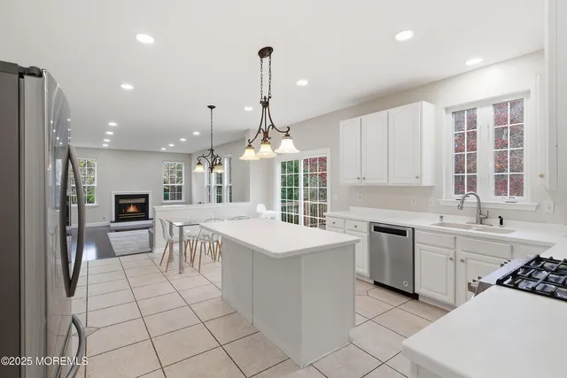 a kitchen with stainless steel appliances granite countertop a sink and a refrigerator