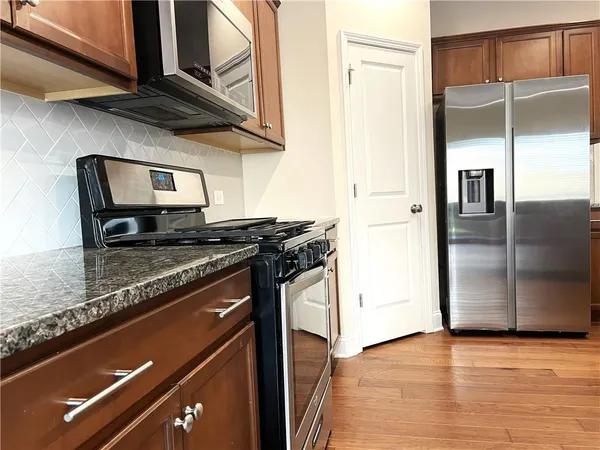 a kitchen with stainless steel appliances granite countertop a refrigerator and a stove