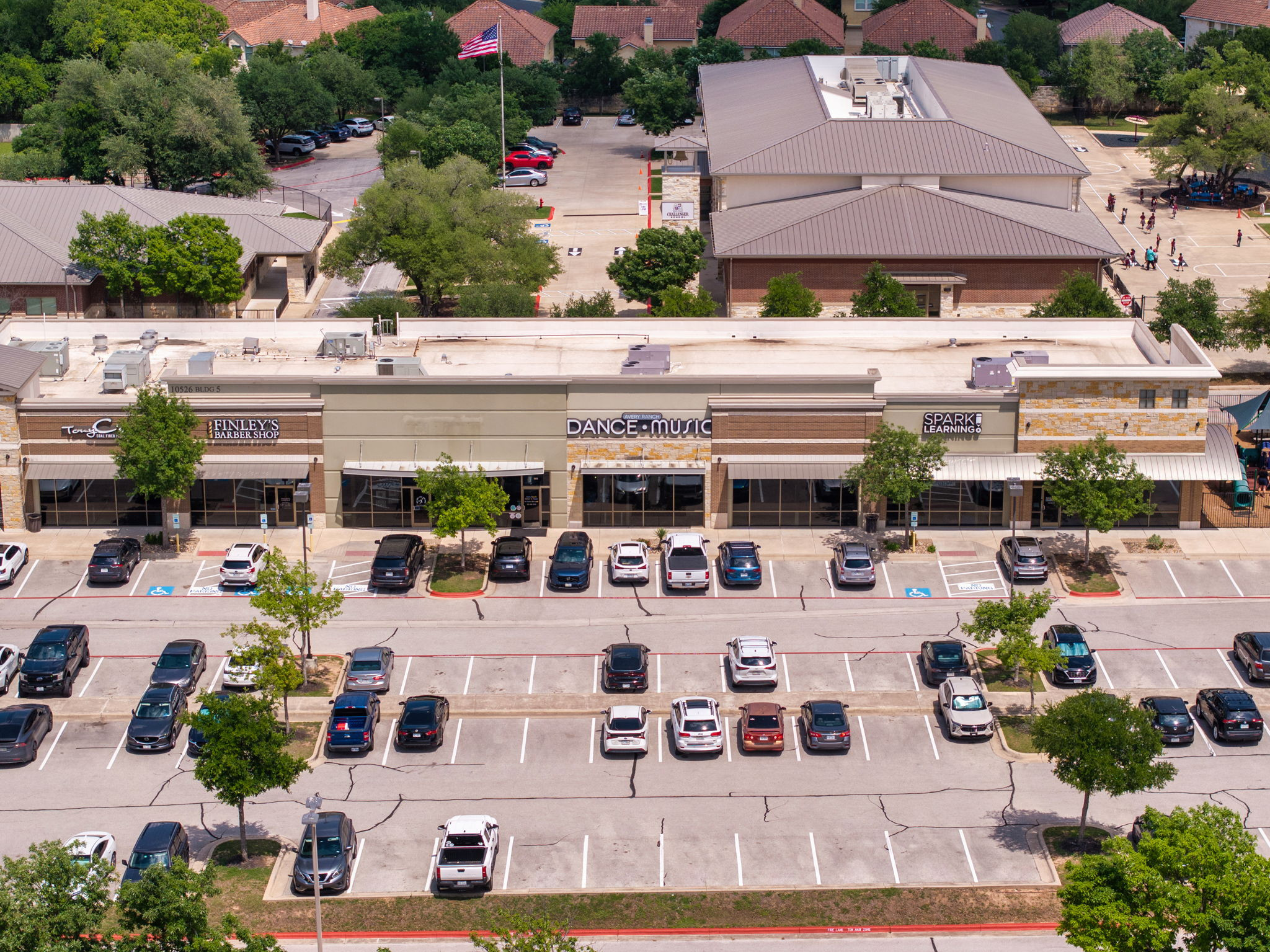 14815 Avery Ranch Boulevard, Unit 1401 Austin, TX 78717 - Photo 33 of 38 Commercial plaza featuring multiple storefronts, extensive parking, mature landscaping, brick and stone facades, and awnings
