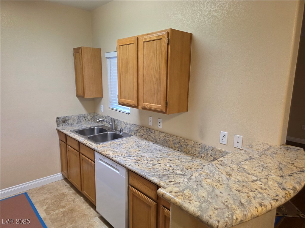 7255 West Sunset Road, Unit 1171 Las Vegas, NV 89113 - Photo 3 of 12 Kitchen with baseboards, a sink, light tile patterned flooring, a peninsula, and white dishwasher