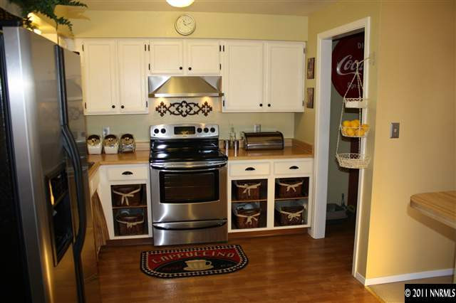 3985 Belmore Way Reno, NV 89503 - Photo 5 of 13 a kitchen with stainless steel appliances a stove a refrigerator and cabinets