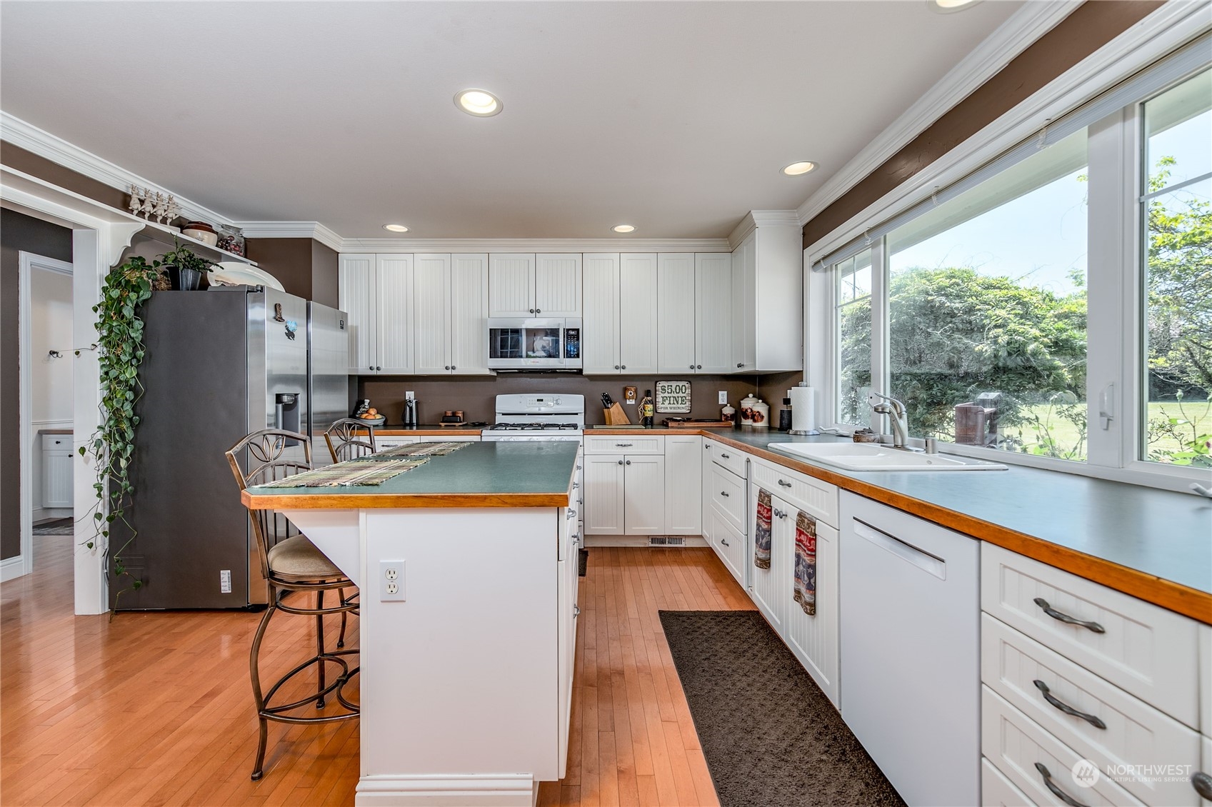174 Lot 9&10 Knutsen Farm Road Sequim, WA 98382 - Photo 15 of 40 a large kitchen with stainless steel appliances granite countertop a refrigerator a sink dishwasher a stove and white countertops with wooden floor
