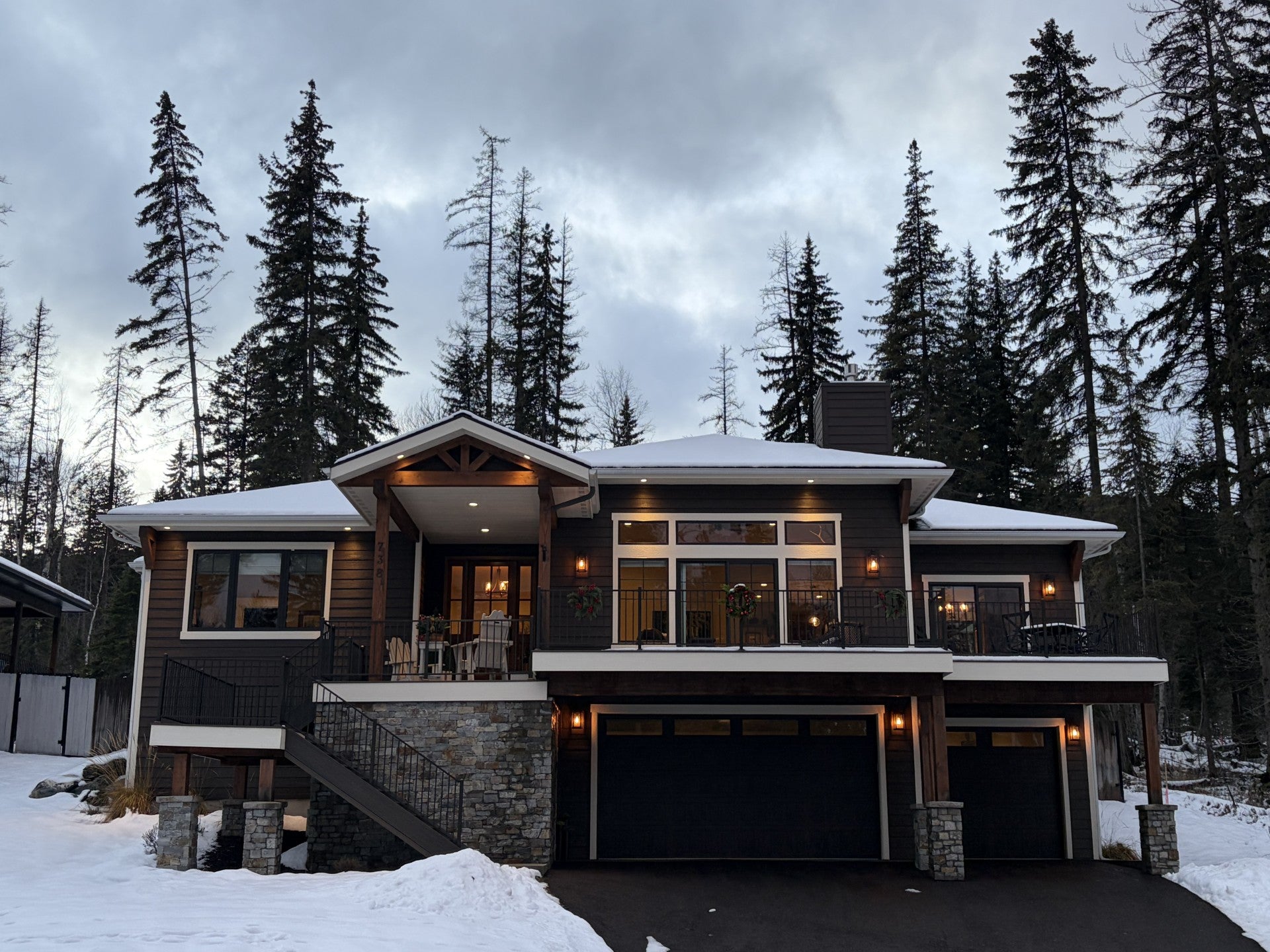 738 Icehouse Road Whitefish, MT 59937 - Photo 1 of 1 View of front of house with a balcony, stairway, a chimney, stone siding, and an attached garage