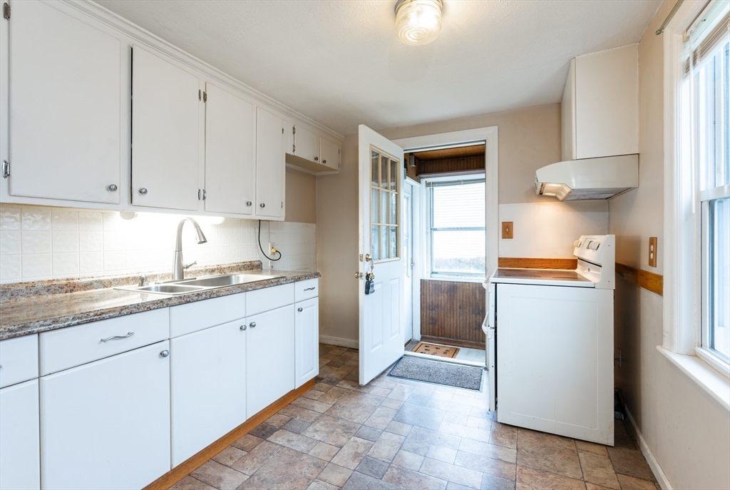 11 Colonial Road Woburn, MA 01801 - Photo 3 of 39 a kitchen with granite countertop a sink and a stove top oven