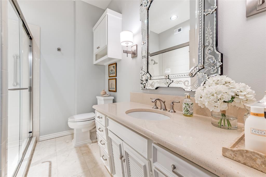 6306 Bandera Avenue, Unit B Dallas, TX 75225 - Photo 12 of 14 Bathroom featuring a glass-enclosed shower, single vanity with light-colored countertop, decorative wall mirror, and tile flooring