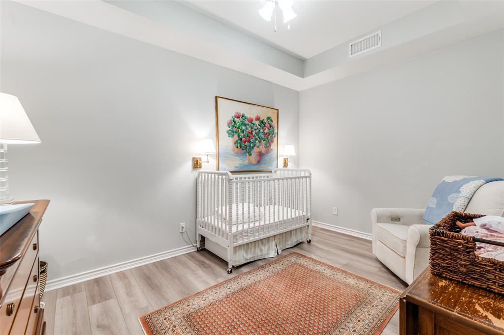 6306 Bandera Avenue, Unit B Dallas, TX 75225 - Photo 13 of 14 Spacious room featuring light gray walls, white baseboards, wood-finish flooring, and a tray ceiling with a ceiling fan
