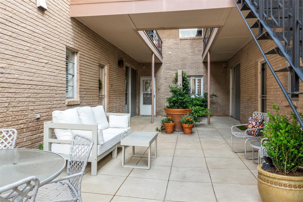 6306 Bandera Avenue, Unit B Dallas, TX 75225 - Photo 14 of 14 Courtyard patio featuring large format tile flooring, brick exterior walls, and a multi-level layout