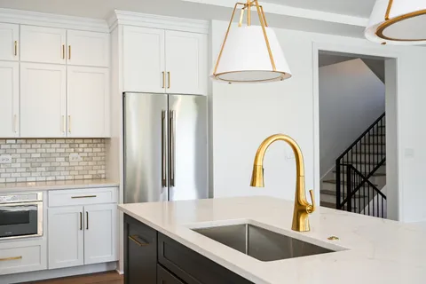 a kitchen with a refrigerator sink and cabinets