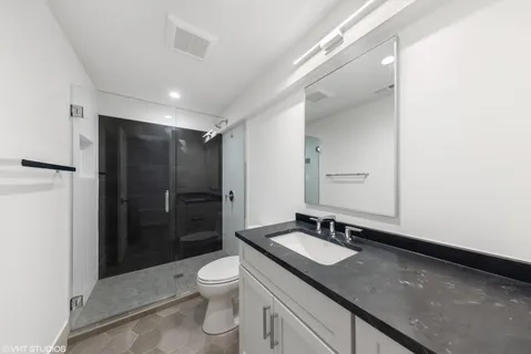 a bathroom with a sink a toilet and shower