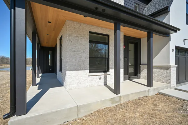 a large kitchen with a center island wooden floor stainless steel appliances and windows