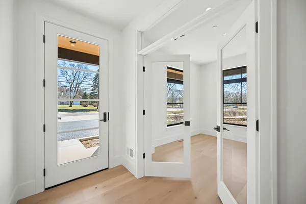 a view of a hallway with wooden floor and closet area