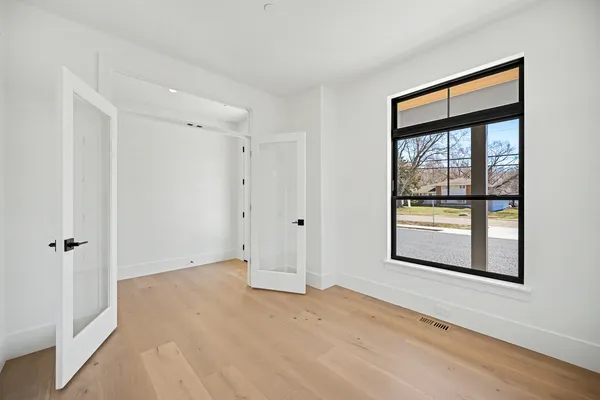 a bedroom with a bed window and a flat screen tv
