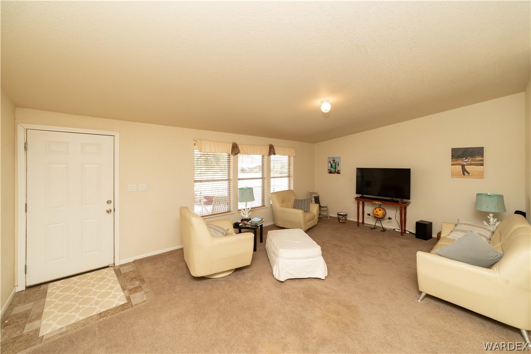 3249 West Carmichael Road Golden Valley, AZ 86413 - Photo 4 of 88 a living room with furniture and a flat screen tv