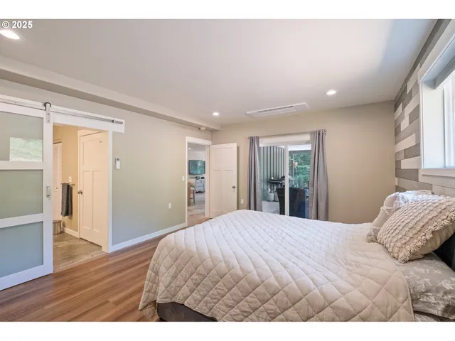 a bedroom with a bed and a large window