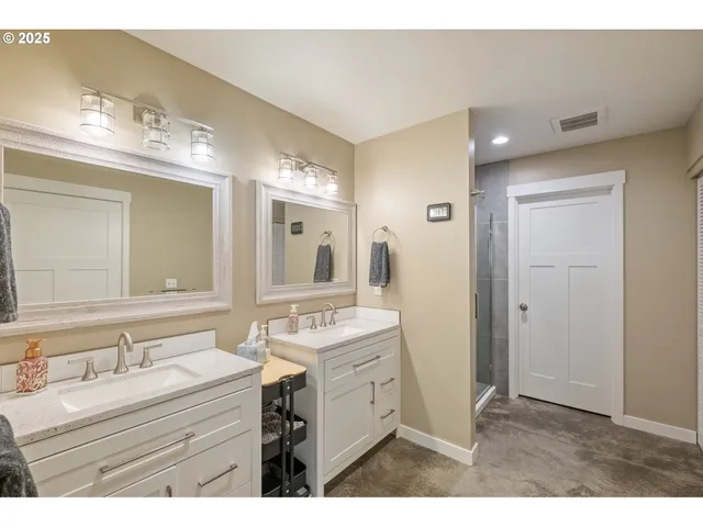 a bathroom with a sink vanity granite tub and a mirror