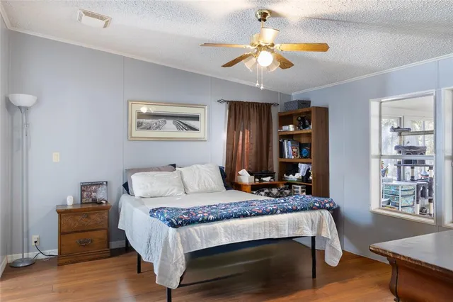 a bedroom with a bed wooden floor and window