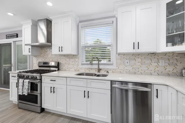 a kitchen with white cabinets and a stove top oven