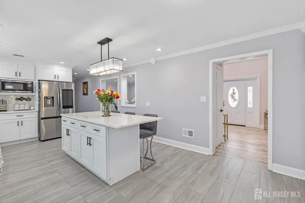 a kitchen with wooden floors and white cabinets