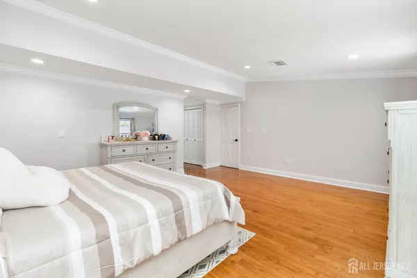 a spacious bedroom with a bed and a wooden floor