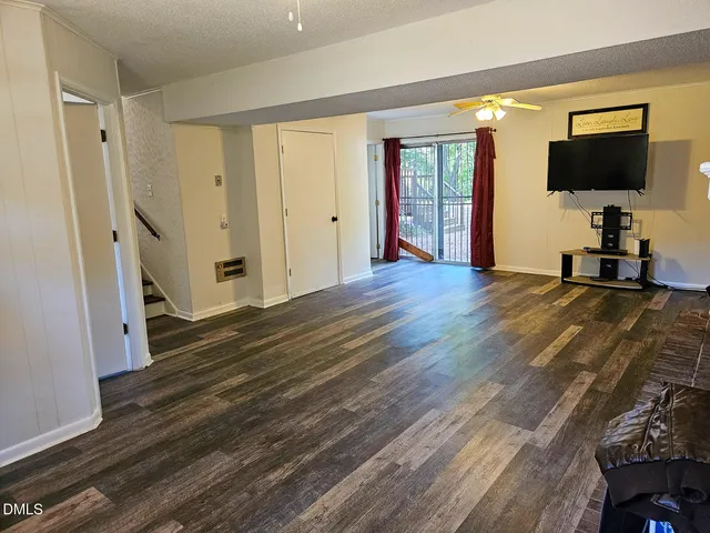a view of a livingroom with wooden floor and a flat screen tv