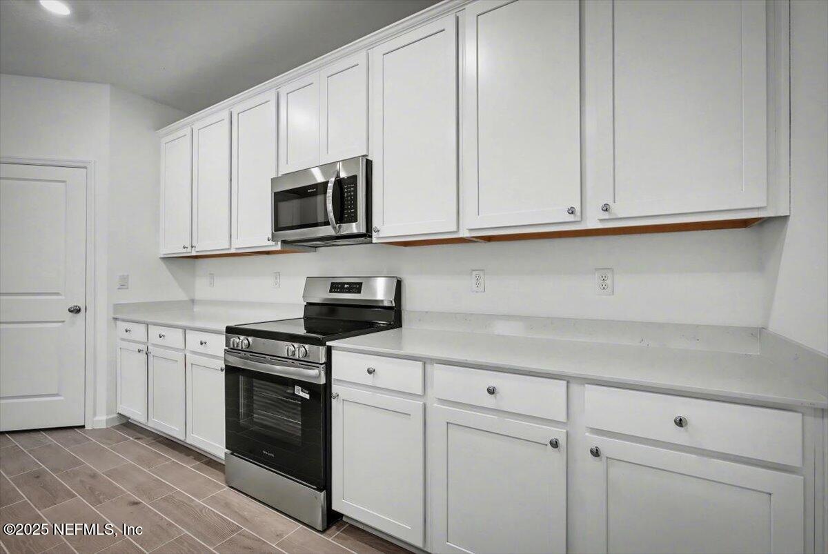 2692 Field Daisy Ln Green Cove Springs Green Cove Springs, FL 32043 - Photo 11 of 37 a kitchen with white cabinets and stainless steel appliances