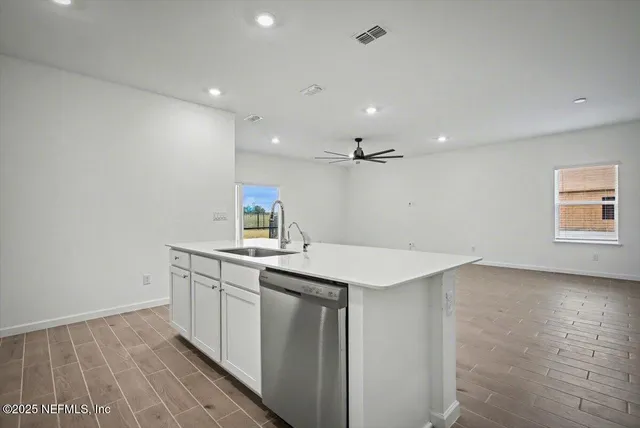 a kitchen with a sink cabinets and wooden floor