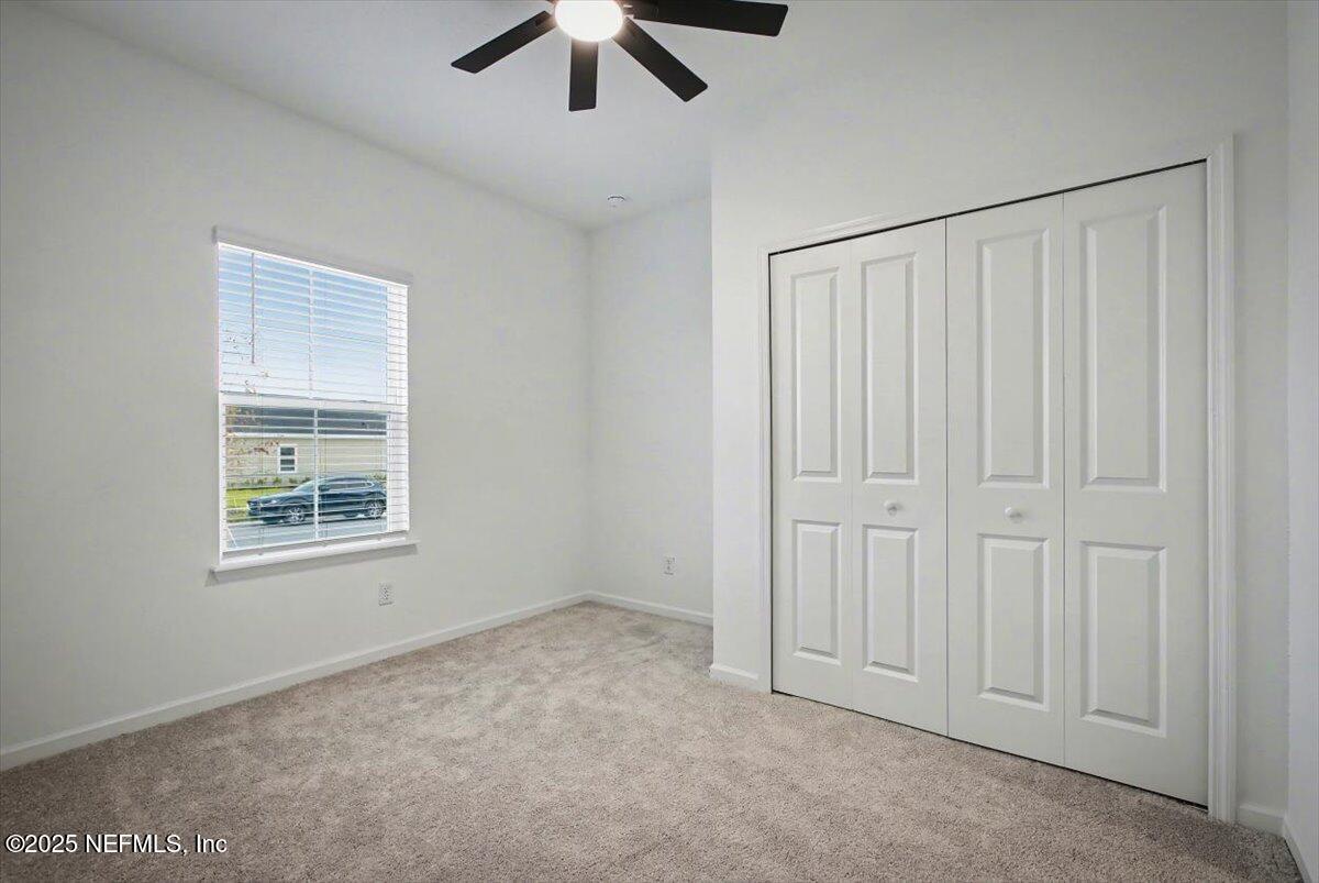 2692 Field Daisy Ln Green Cove Springs Green Cove Springs, FL 32043 - Photo 13 of 37 en empty room with windows and ceiling fan