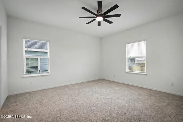 an empty room with a window and a fan