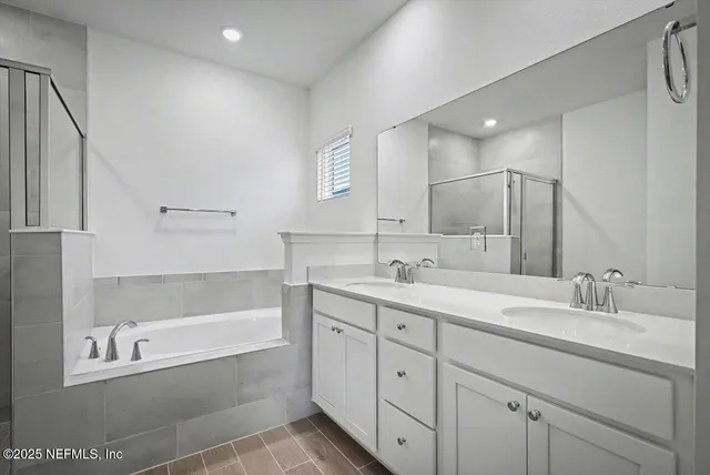a bathroom with a tub sink and mirror