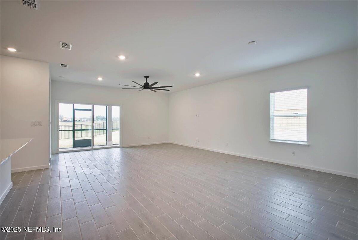 2692 Field Daisy Ln Green Cove Springs Green Cove Springs, FL 32043 - Photo 5 of 37 an empty room with wooden floor and windows
