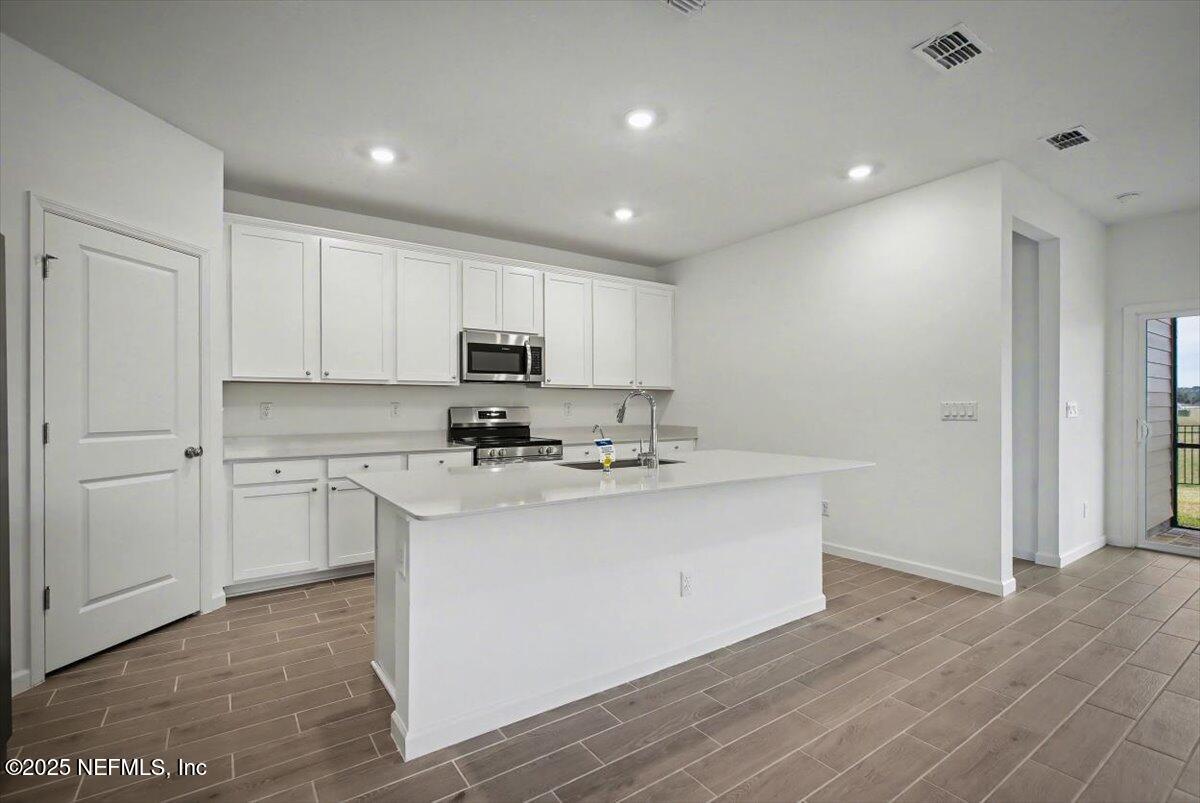 2692 Field Daisy Ln Green Cove Springs Green Cove Springs, FL 32043 - Photo 8 of 37 a kitchen with stainless steel appliances granite countertop a sink a stove a refrigerator and cabinets