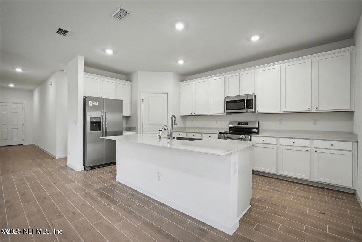 2692 Field Daisy Ln Green Cove Springs Green Cove Springs, FL 32043 - Photo 10 of 37 a kitchen with white cabinets and stainless steel appliances