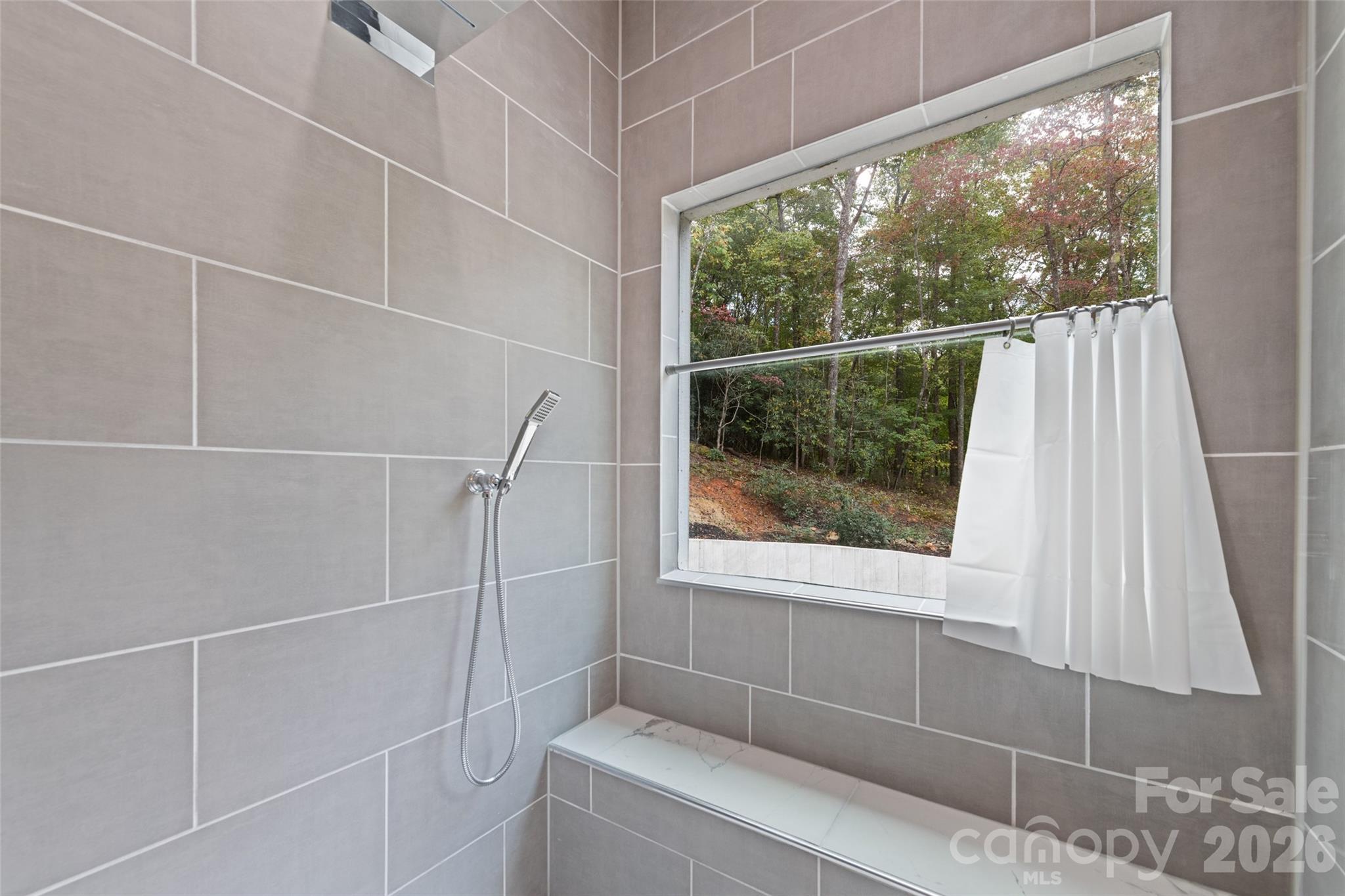 1185 Wallalieu Road Otto, NC 28763 - Photo 24 of 43 a bathroom with a window and a shower