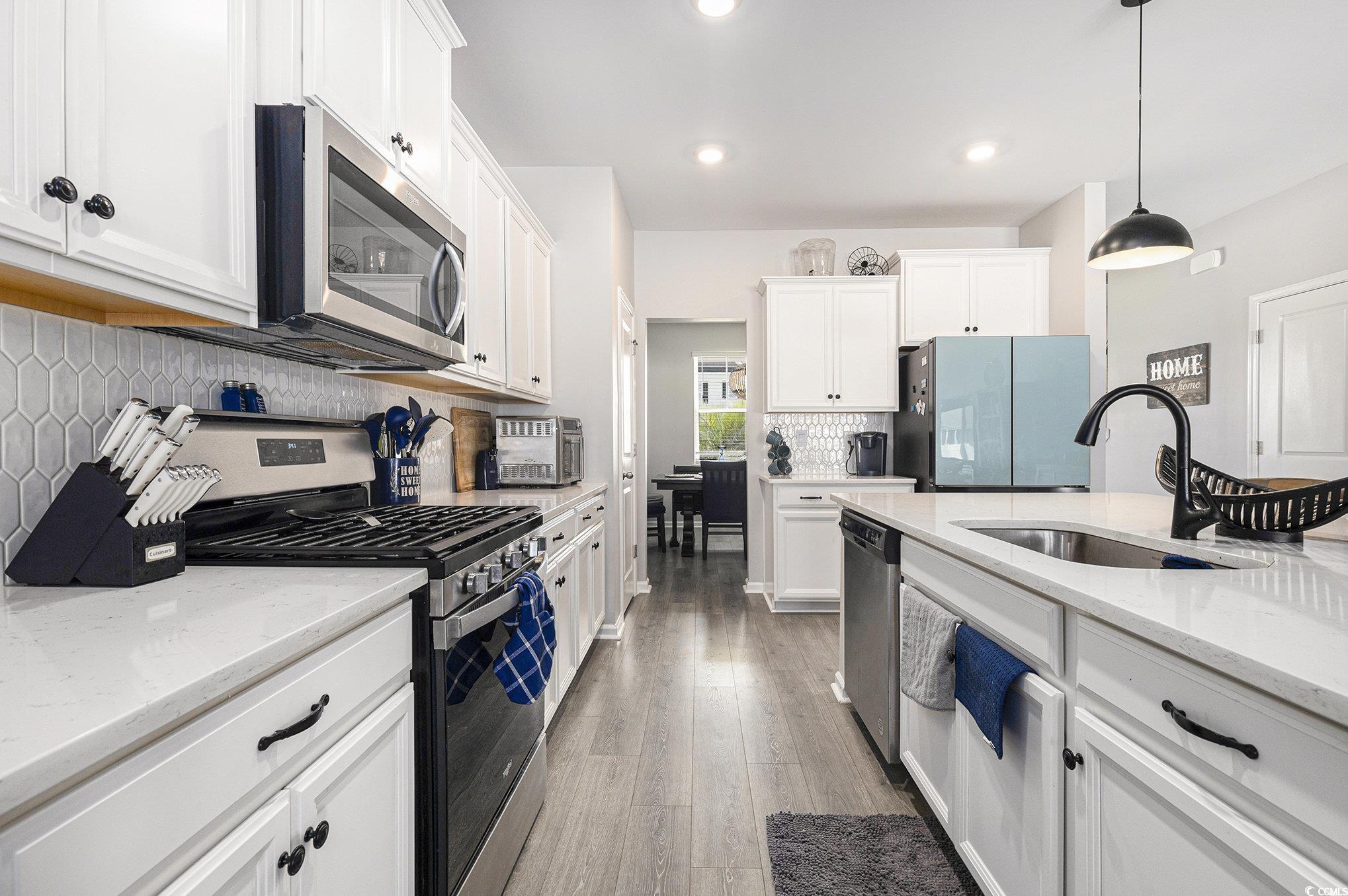 312 Cattle Drive Circle Myrtle Beach, SC 29588 - Photo 34 of 34 Kitchen with stainless steel appliances, open floor plan, white cabinetry, wood finished floors, and recessed lighting