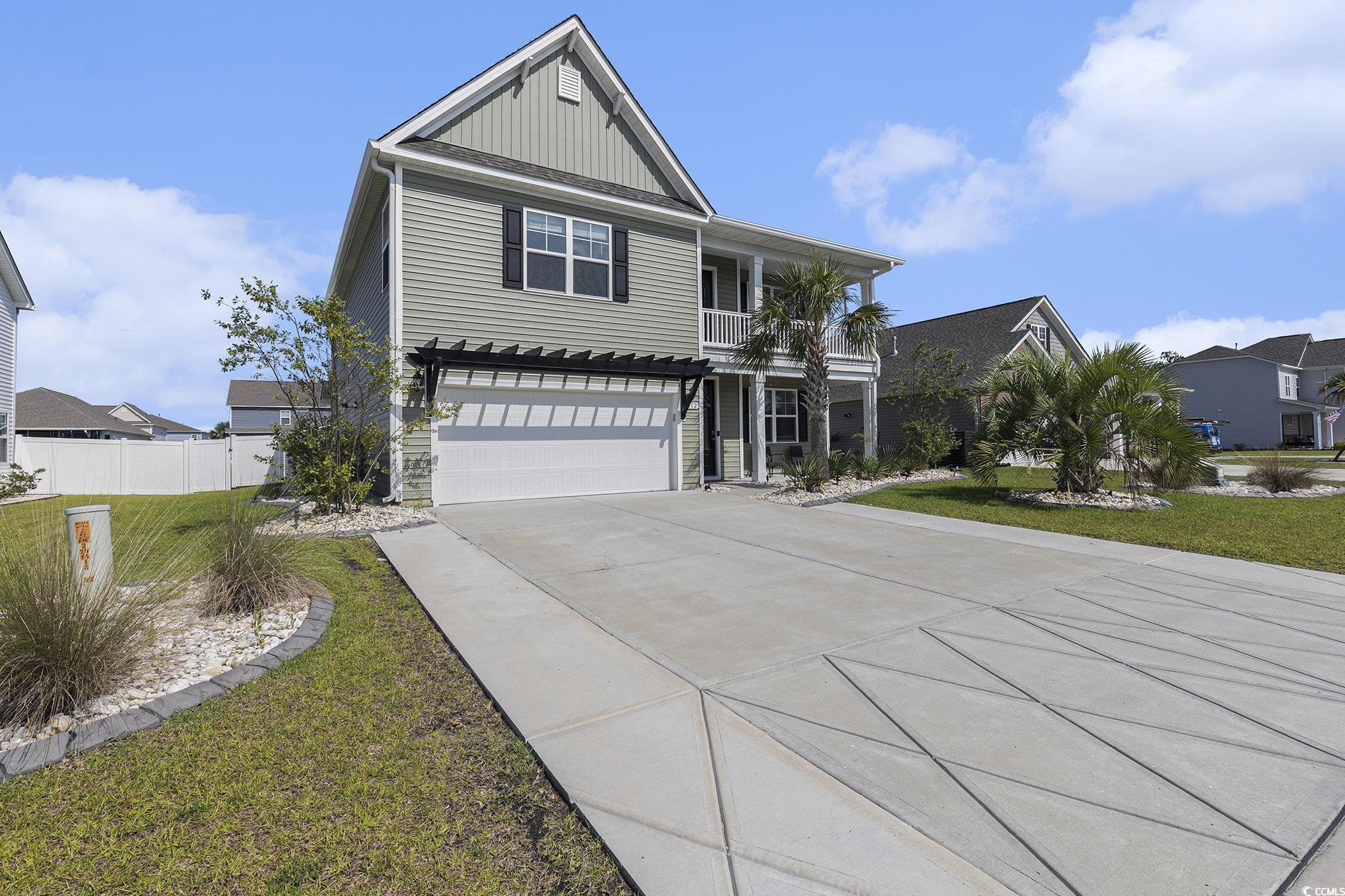 312 Cattle Drive Circle Myrtle Beach, SC 29588 - Photo 2 of 34 View of front of property with board and batten siding, concrete driveway, a garage, a balcony, and a residential view